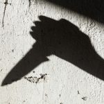 Hand with knife in silhouette