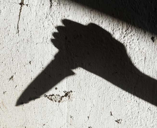 Hand with knife in silhouette