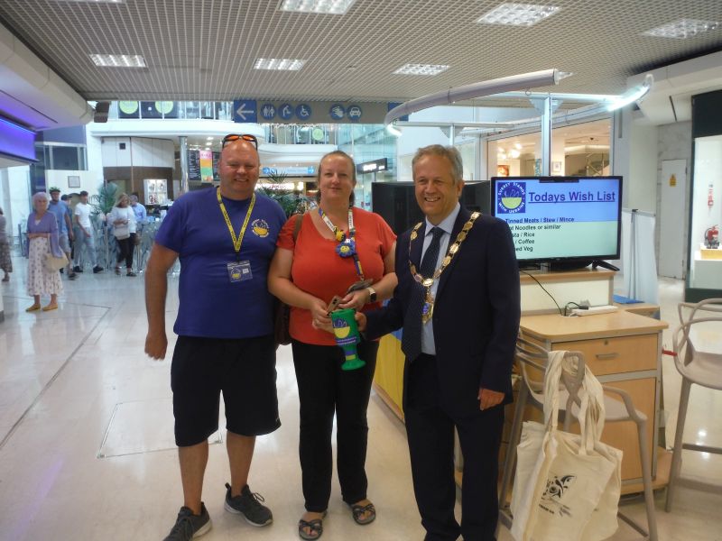Ron and Anne-Marie Carlin of Surrey Stands With Ukraine stand with Mayor Clive Woodbridge of Epsom and Ewell in the Ashley Centre