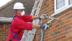Worker insulating a house.