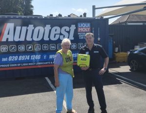Bess Harding of EMEG gives defibrillator to Stephen Hardie-East of Autotest