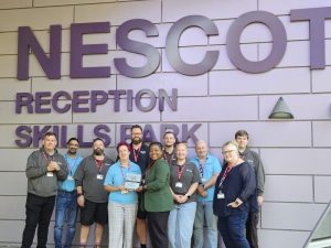 Photo: (centre left to right): Nescot Principal and CEO Julie Kapsalis receiving the City & Guilds EPA Award plaque from Elizabeth Akinlaja, City & Guilds Business Development Manager for London, Kent & Sussex along with the Nescot Plumbing team. Photo credit: Nescot