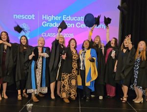 Nescot higher education students throw their caps in the air