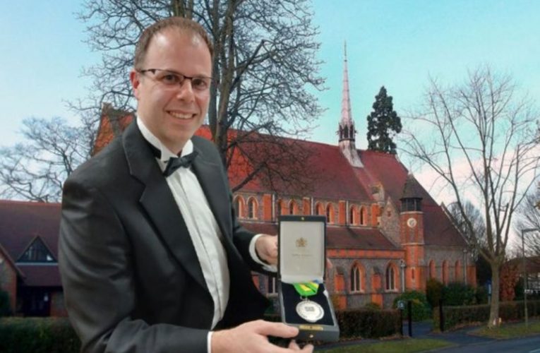Karl Nicholas against the background of St Mary's Church