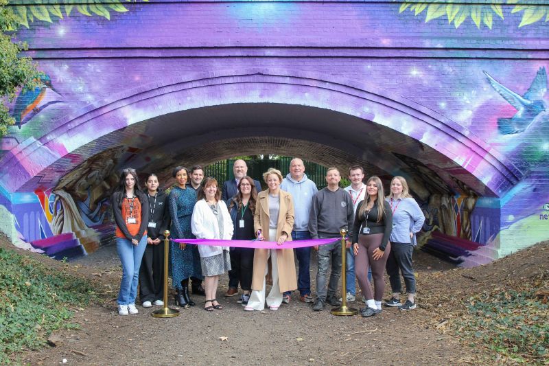 Staff and students from Nescot with the newly painted underpass they worked on.