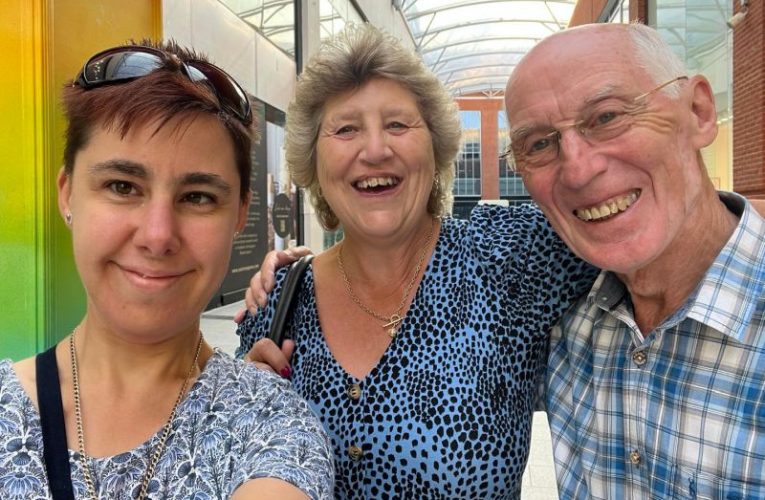Home sharers and guest smiling at camera