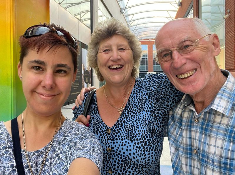 Home sharers and guest smiling at camera