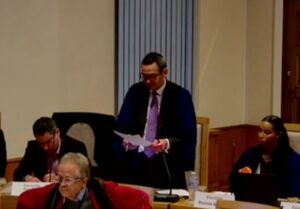 McCormick speaks, Coley to his left and Goldman to his right. Woodbridge in foreground. EEBC YouTube