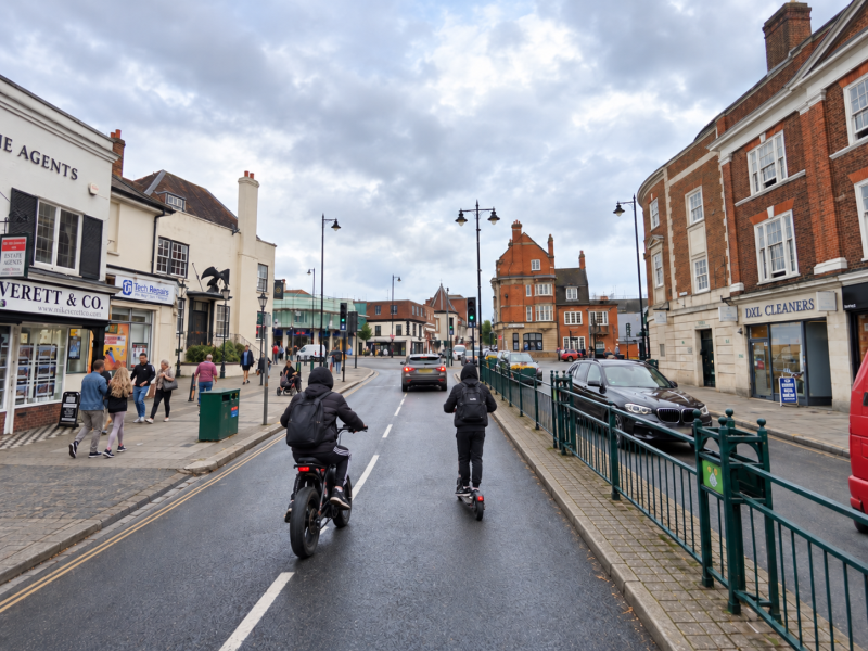 Young e-bike and e-scooter riders in Epsom High Street. Idealised by AI